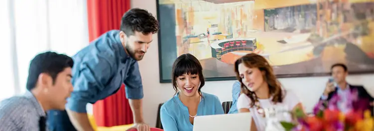 Attendees looking at a computer screen in a meeting room