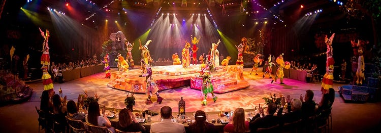 Attendees sitting at long tables while watching a spectacular stage show