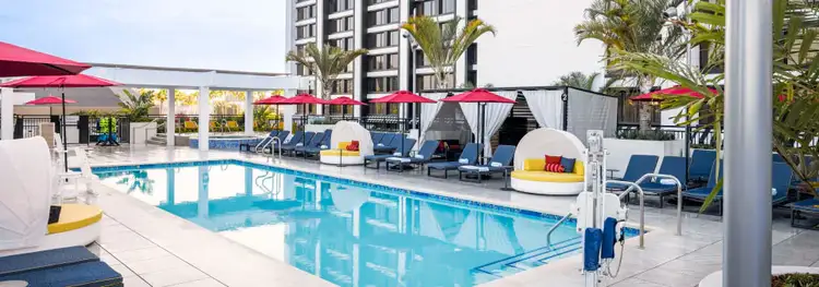 Rooftop pool deck with cabanas, umbrellas, poolside chairs and palms outside the Pixar Place Hotel