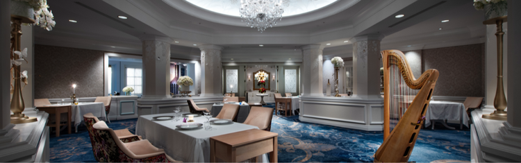 Elegant dining room at Victoria & Albert's featuring a crystal chandelier, harp and set tables