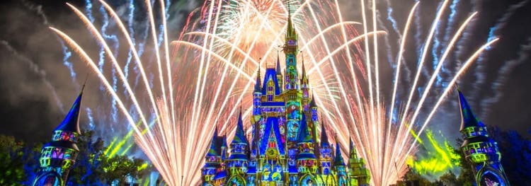 Fireworks burst over Cinderella Castle as lights cover it in a stained glass theme