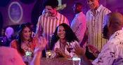 Guests gathered around a table while chatting and enjoying beverages