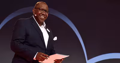 A man speaking onstage at an event at the Disney Institute