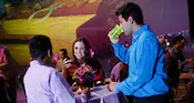 Guests chatting and enjoying beverages while standing at a cocktail table