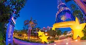 Entrance to the Disneyland Hotel at dusk with Sorcerer Mickey’s hat decoration, golden stars and palm trees
