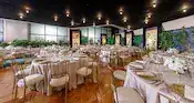 A ballroom with tables, chairs, floral arrangements and artwork featuring sketches of Disney characters