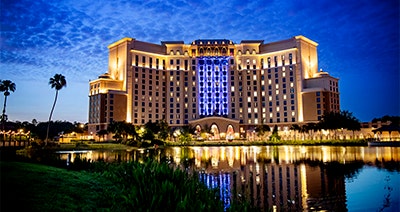 Gran Destino Tower at Disney's Coronado Springs Resort illuminated at night near a lake