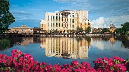 The Gran Destino Tower at Disney’s Coronado Springs Resort, adjacent to the waterfront restaurant Villa del Lago, is reflected on the nearby lake