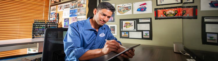 Man holding a tablet inside a creative studio, reviewing event design concepts