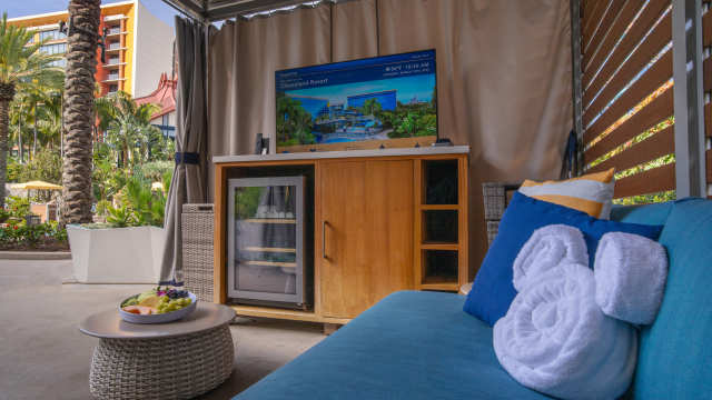 A private pool cabana with a TV, mini fridge, fresh fruit and towels at Disneyland Hotel