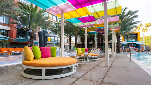 Round lounge chairs and a pergola on the pool deck at Disneyland Hotel