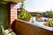 A balcony with chairs and a view of the pool area