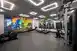 A gym with several exercise machines and artwork featuring Mike and Sully from 'Monsters Inc'