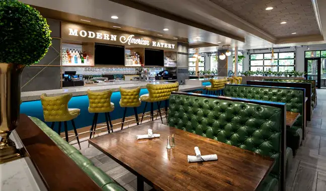 A restaurant and bar decorated with mid century modern décor with a sign that says ' Modern American Eatery'