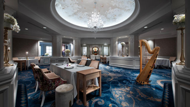 Elegant dining room at Victoria & Albert's featuring a crystal chandelier, harp and set tables