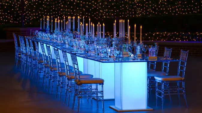 Outdoor event setup with illuminated tables and candles