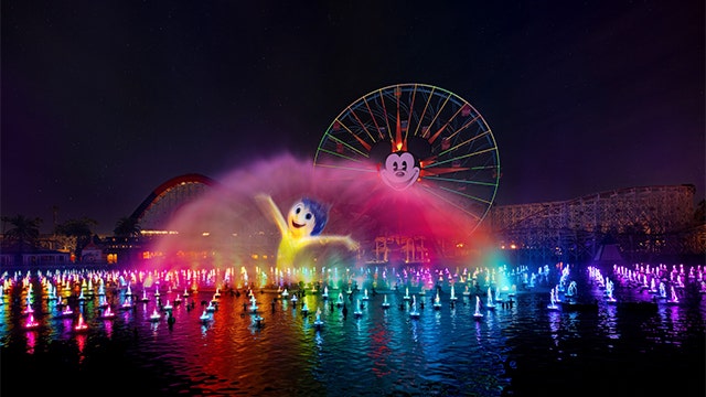 Illuminated fountains and a projection of Joy during World of Color, a nighttime water show at Disney California Adventure